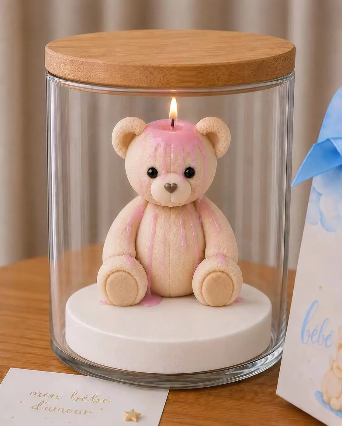 Pink-finished sculpted teddy bear candle inside a clear glass display jar with a natural wood lid
