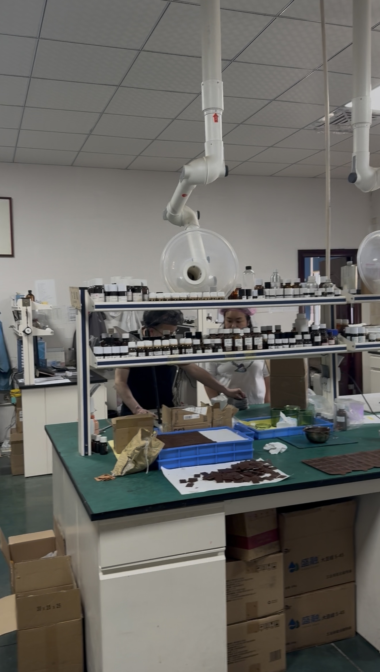 Staff working at a fragrance sample bench with bottles and local extraction equipment